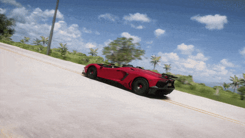 a red sports car is driving down the road