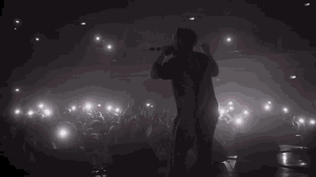 a man singing into a microphone in a dark room