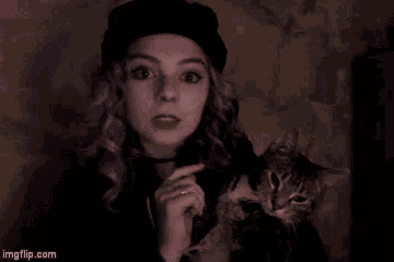 a girl with purple hair is holding a cat in her arms and the url for imgflip.com is below her