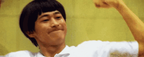 a man is flexing his muscles and making a face .