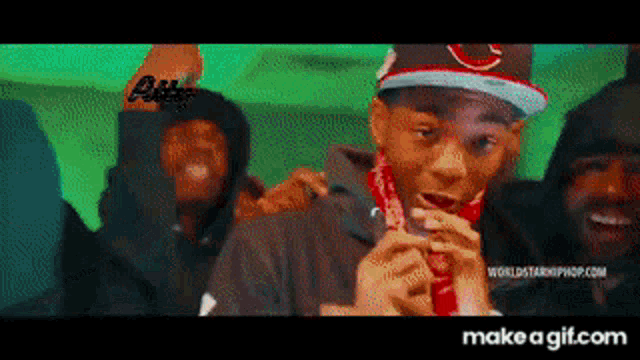 a group of young men are standing next to each other and one of them is wearing a red bandana .
