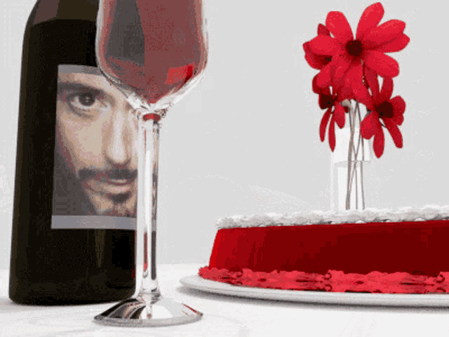 a bottle of wine with a picture of a man on it next to a cake