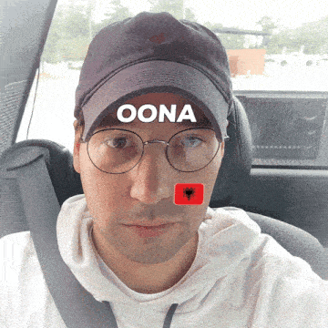 a man wearing glasses and a hat with the word oona on it