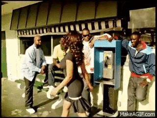 a group of people standing around a phone booth with makeagif.com at the bottom of the screen