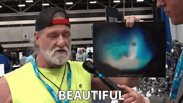 a man in a yellow shirt is holding a picture with the word beautiful written on it