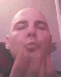 a bald man is making a funny face with his hands .