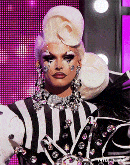 a drag queen is wearing a black and white striped outfit with rhinestones