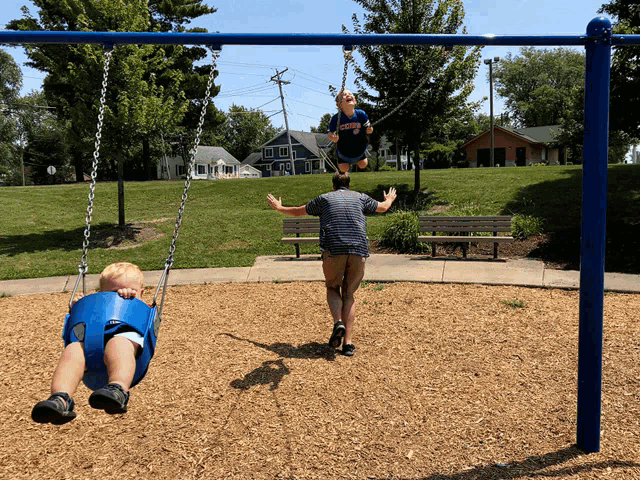 a boy wearing a shirt that says ' eagles ' on it is swinging on a swing