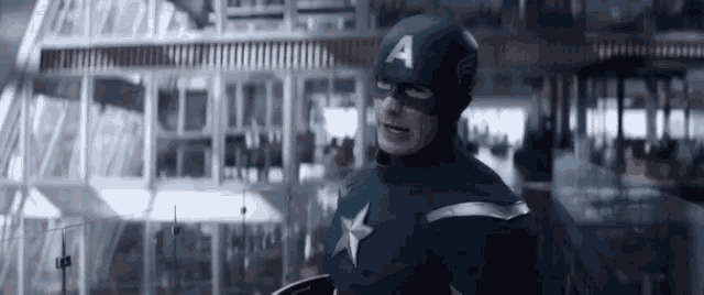 a man in a captain america costume is holding a shield in his hand .