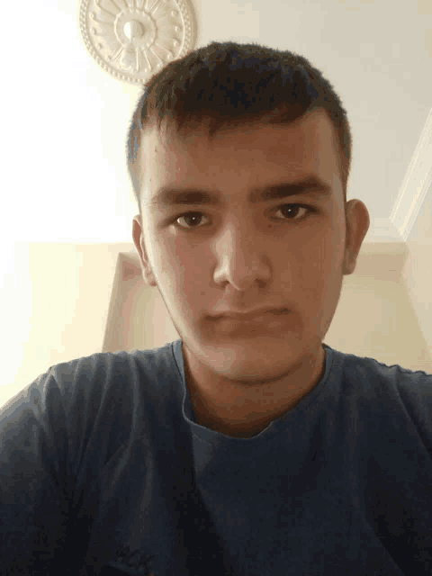 a young man taking a selfie with a clock on the ceiling