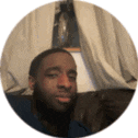 a man with a beard is sitting on a couch taking a selfie .