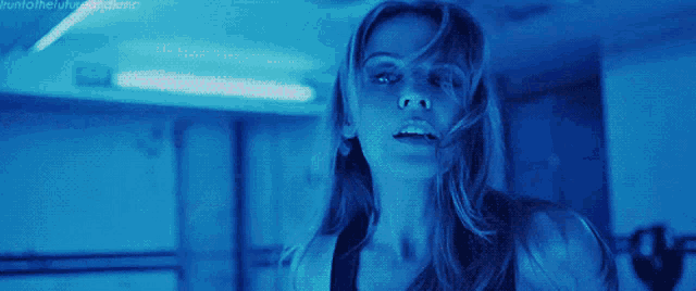 a close up of a woman 's face with a blue light behind her and the words " hunt for the killer queen "
