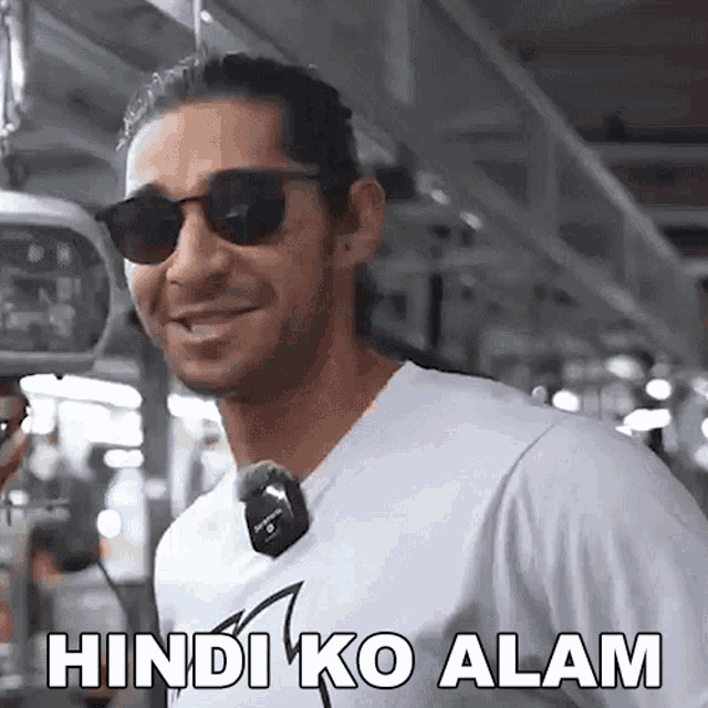 a man wearing sunglasses and a white shirt is smiling and saying hindi ko alam