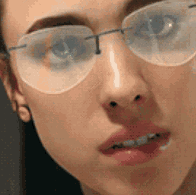 a close up of a woman wearing glasses making a funny face .