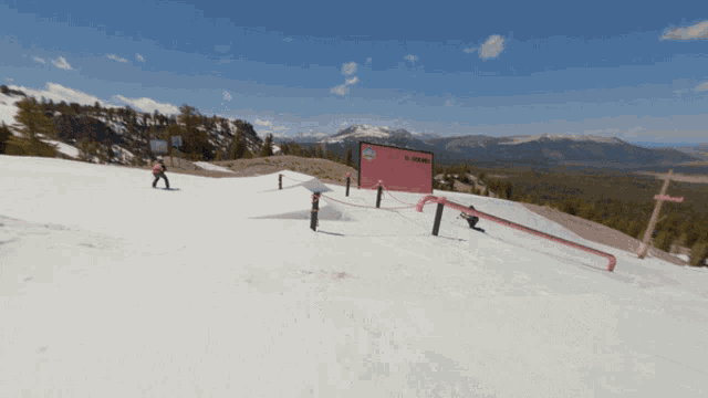 a person skiing down a snow covered slope with a red sign that says ' salomon ' on it