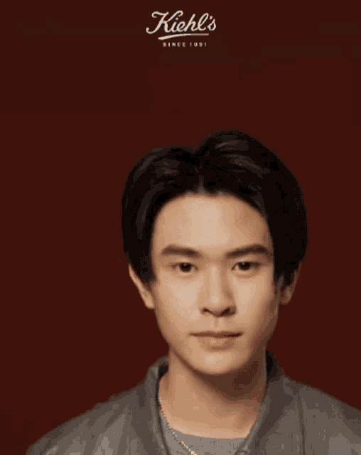 a young man is making a sad face in front of a kiehl 's advertisement