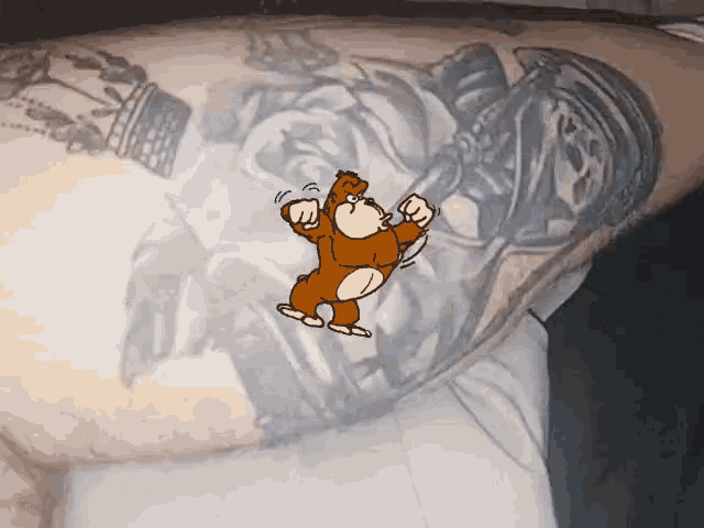 a cartoon monkey is flexing his muscles on a person 's arm