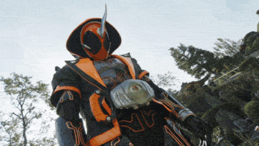 a person in a black and orange costume with a belt that says ' nm ' on it