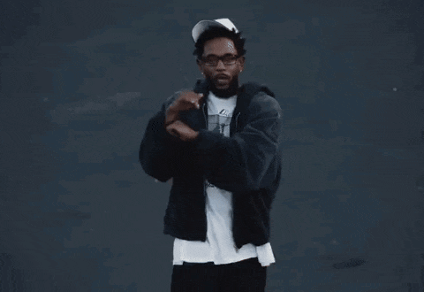 a man wearing a black jacket and a white hat with the letter r on it is dancing