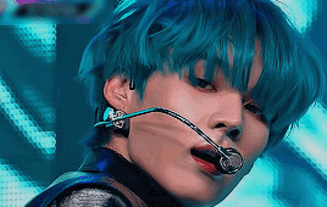 a close up of a person with blue hair and a microphone