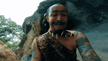 a man with a tiger print shirt and a necklace of teeth