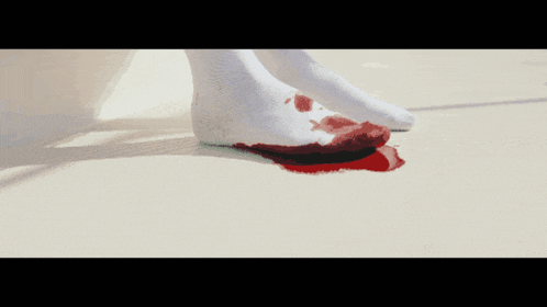 a person 's foot is covered in blood on a white floor