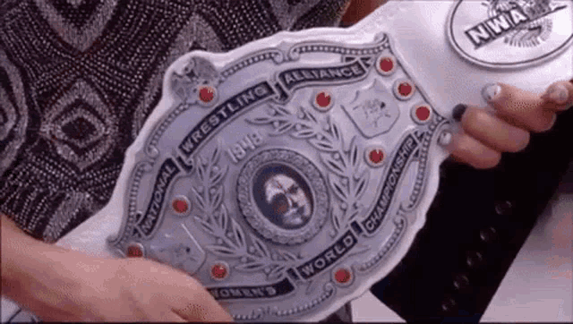 a woman is holding a national wrestling alliance belt from 1918