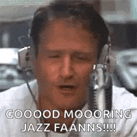 a man wearing headphones is talking into a microphone and saying `` good moooring jazz faanns !!! '' .