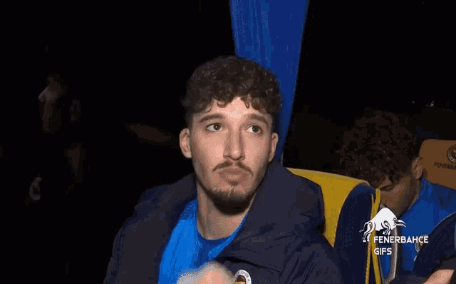 a man in a blue jacket with fenerbahce gifs on the bottom right