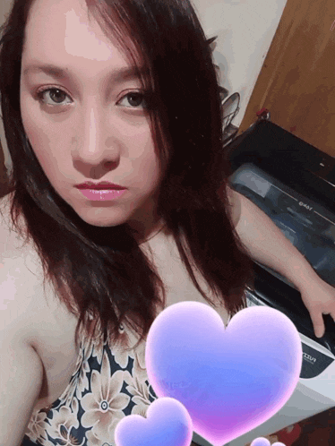 a woman taking a selfie in front of a sharp stove top oven