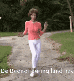 a woman in a pink shirt and white pants is walking down a path .