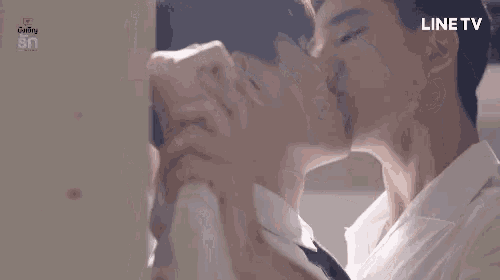 two men are kissing each other on the cheek while standing next to each other .