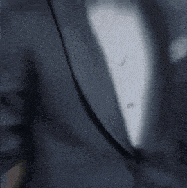 a man in a tuxedo with a bow tie is standing with his hands in his pockets