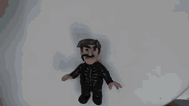 a clay figure of a man with a mustache is giving the thumbs up sign