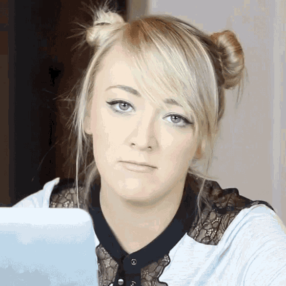 a blonde woman with two buns on her hair looks at the camera