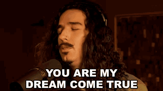 a man singing into a microphone with the words " you are my dream come true " below him