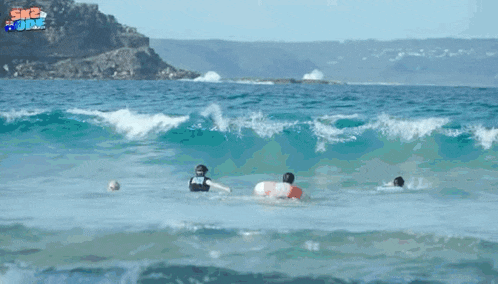 a group of people are swimming in the ocean with a sign that says sk2 june in the background