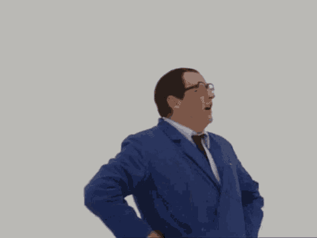 a man wearing glasses and a blue jacket with his hands on his hips