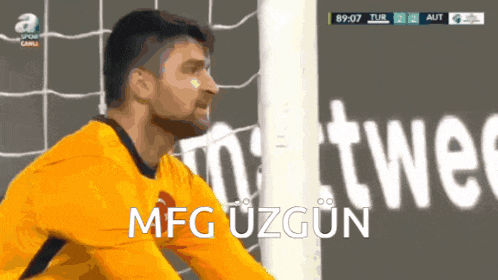 a soccer goalie named mfg uzgun stands in front of a goal