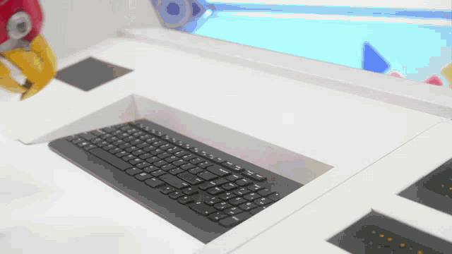 a black keyboard is sitting on a white surface
