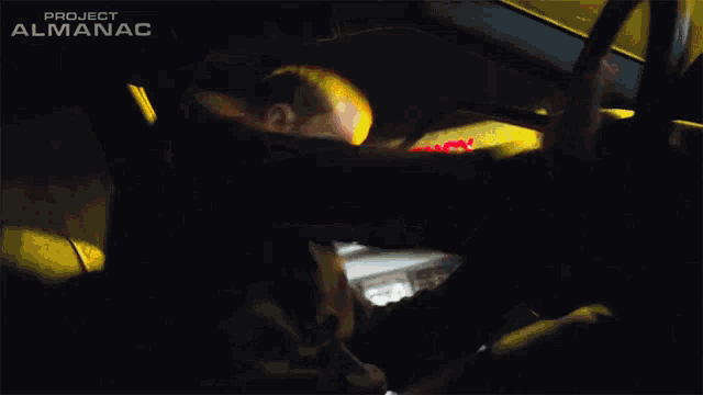 a man is driving a car in front of an emergency room