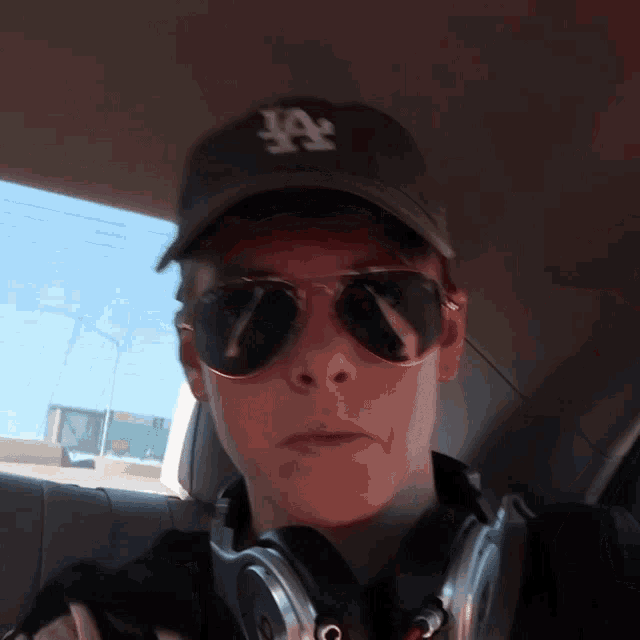 a person wearing sunglasses and a la hat