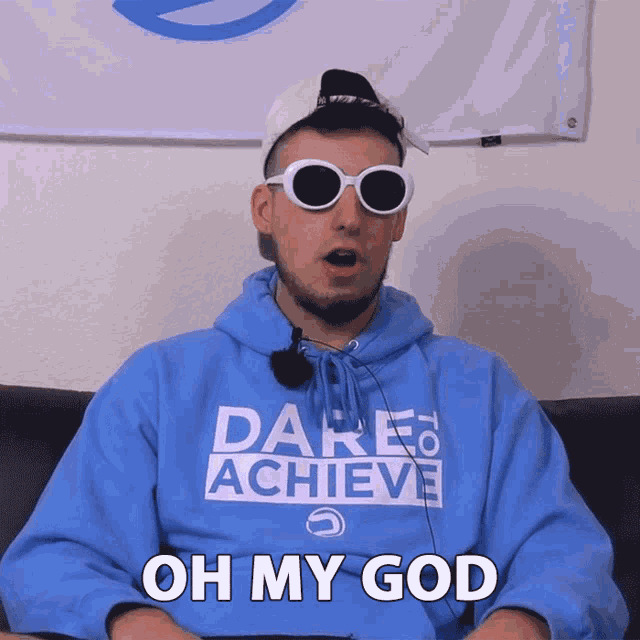 a man wearing sunglasses and a dare to achieve sweatshirt says oh my god