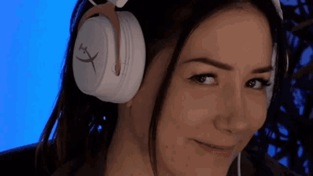a close up of a woman wearing headphones and making a funny face .