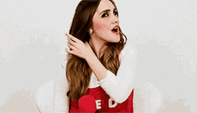 a woman wearing a red vest that says ed on it