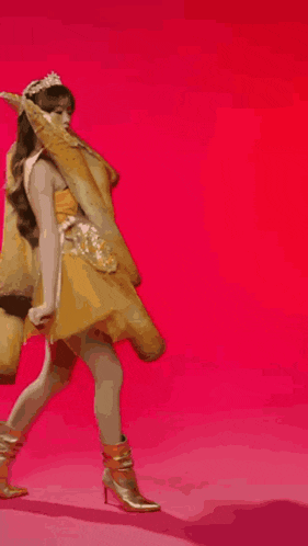 a woman is wearing a tiara and holding a giant taco in her hands .