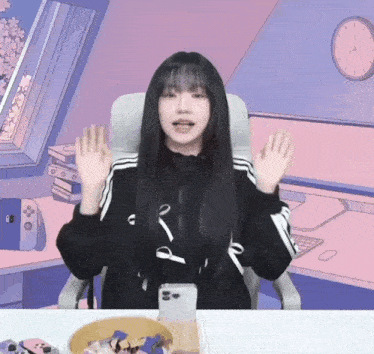 a girl sitting in a chair with her hands up