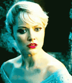 a close up of a woman 's face with blonde hair and red lipstick
