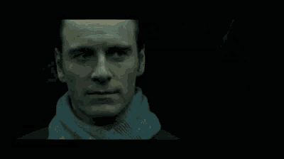 a close up of a man 's face in front of a drawing on a wall .