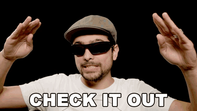 a man wearing sunglasses and a hat with check it out written on his shirt